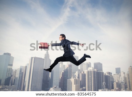 Businessman running with cityscape in the background