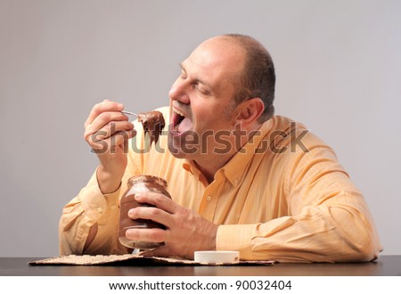Fat man eating chocolate cream