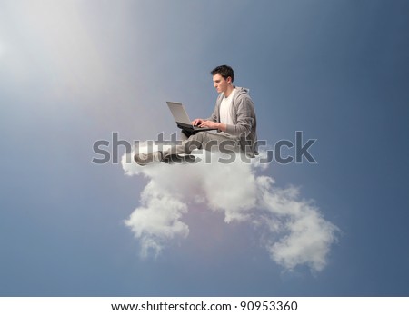 Young man sitting on a cloud and using a laptop