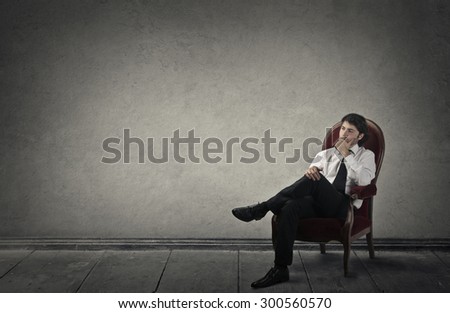 Young businessman sitting in a red chair