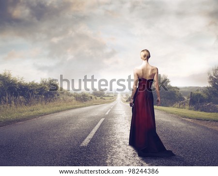 Beautiful elegant woman walking on a country road