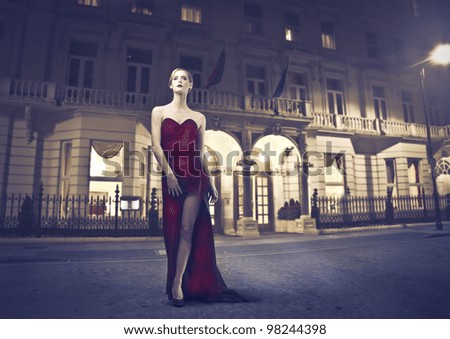 Beautiful elegant woman standing in front of a luxury palace