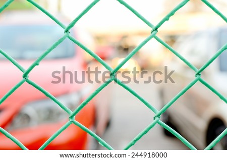 Car in The Cage, Close Up Green Wire Mesh at Car Park.