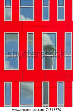 modern glass building with chimney reflection