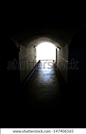 Long tunnel walkway with the white light at the end