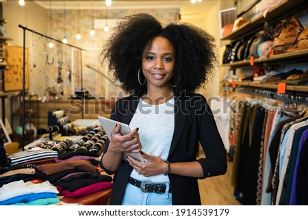 Portrait of the owner of a clothing store at the entrance of the new business with the tablet in hand to analyze the sales, new orders to be sent and check the stocks