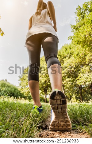 Runner feet running in the park during sunset in a summer day