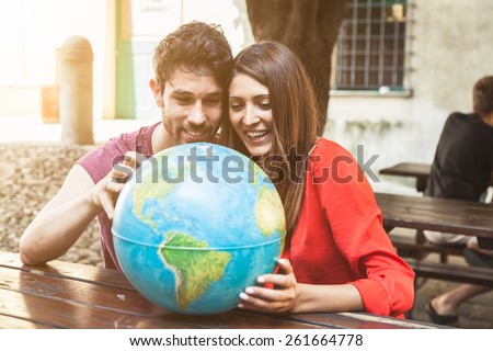 Young couple look the world map to decide the next trip