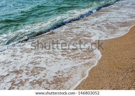 Sea waves run over on the shore and leave a trail of foams
