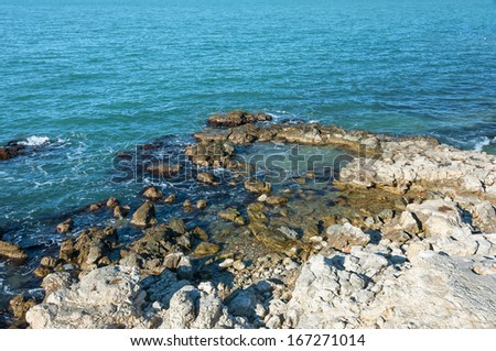 Ukraine, peninsula of Crimea, Sea coast on the Black Sea, large and small pebbles, large boulders, sea waves