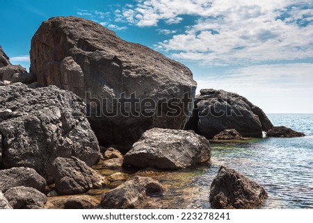 Ukraine, peninsula of Crimea, Sea coast on the Black Sea, large and small pebbles, large boulders, sea waves