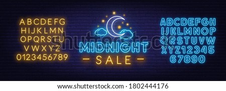 Midnight sale neon sign on a brick wall background.