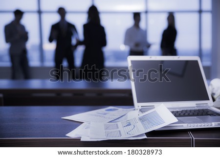 several colleagues communicating in office against window