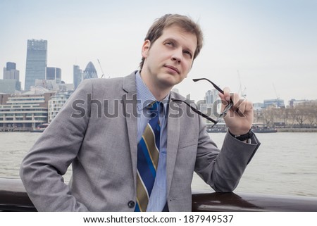 The businessman on the street, background skyscrapers London.  	 holding glasses