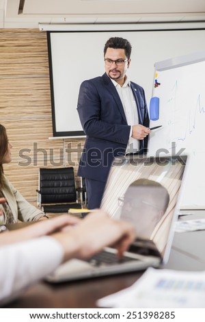 Confident businessman explaining something to colleagues at meeting