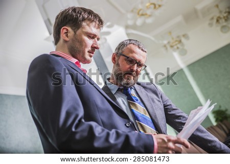 two businessmen discussing financial documents in the office