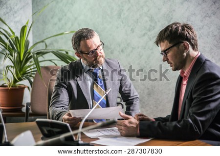 two businessmen in an office, the boss lively explains the subordinate tasks for the day