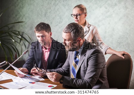 three businesspeople interacting at meeting, colleagues meeting to discuss their future financial plans