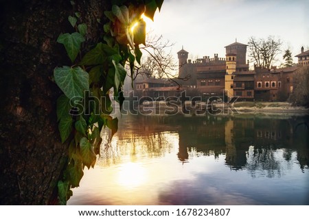 Turin (Piedmont, Italy), the river Po and the famous Borgo Medievale, neo-gothic castle in the Valentino public park at sunset Imagine de stoc © 