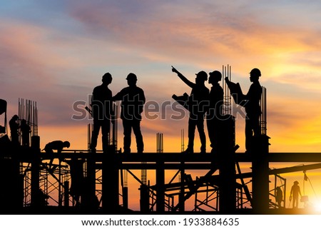 Silhouette of Engineer and worker on building site, construction site at sunset in evening time. Foto stock © 
