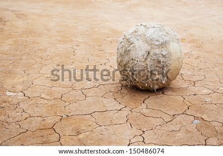Old football on Cracked soil.