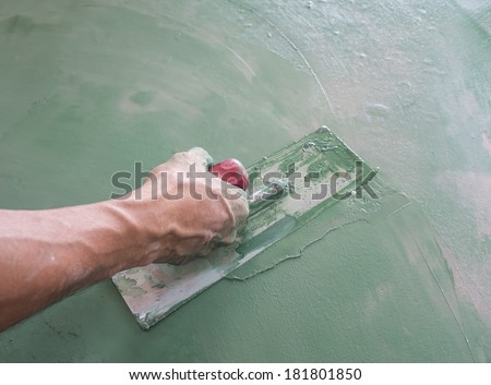 Workers  hand plastering color combination  a wall  with trowel. Construction worker. Masonry tool. Construction industry. Selective focus.