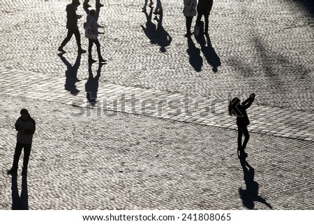 ROME, ITALY - JANUARY 2015, 05: Silhouette people enjoy the warm temperatures in Piazza del Popolo. After days of unusual cold the sun shines back in Rome and temperatures are back to the average.