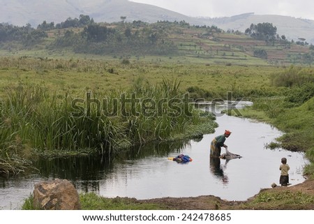 RUGEZI, RWANDA - SEPTEMBER 2008: A woman washing clothes. Rwanda today is a story of renewal and rapid economic development; only 20 years ago the country was torn apart by the genocide