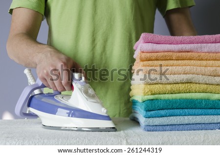 Housework, ironing iron colorful towels on the ironing board.