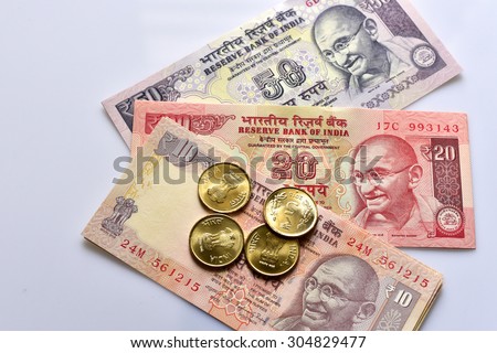 TRIVANDRUM, KERALA, INDIA, AUGUST 08, 2015: Ten, twenty and fifty rupee Indian currency notes and five rupee mint coins on white background. Cost of living in India.