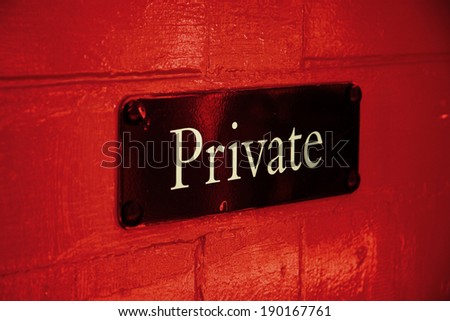 Private sign on red door - angled