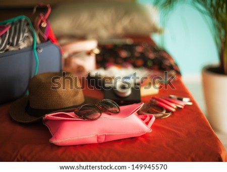 Woman\'s bedroom full of things ready to be taken on summer holiday.