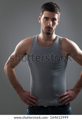 Indoor portrait of a handsome Caucasian man with his arms akimbo.