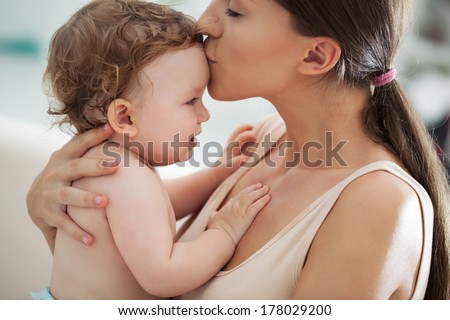 Young mother kissing her adorable baby boy.