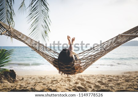 Summer vacations concept, Happy woman with white bikini, hat and shorts Jeans relaxing in hammock on tropical beach at sunset, Koh mak, Thailand Сток-фото © 