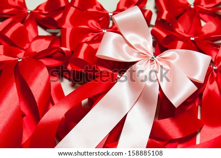 pink ribbon bow on red ribbons background
