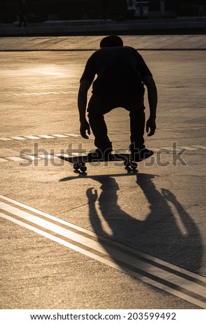 Silhouette of man playing skateboard in park