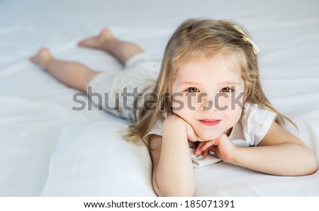 Adorable smiling little girl waked up in her bed