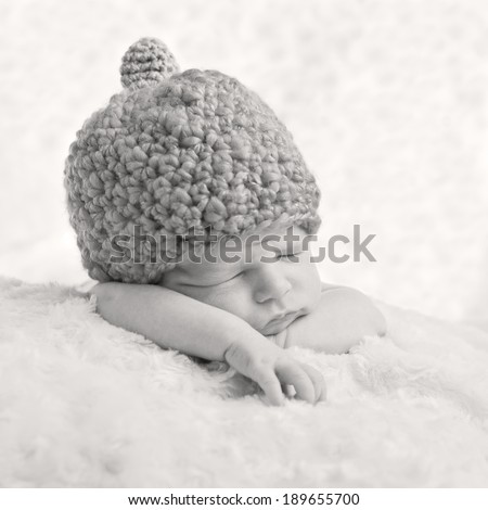 Portrait of a sleeping newborn baby in a knitted hat ( black and white )