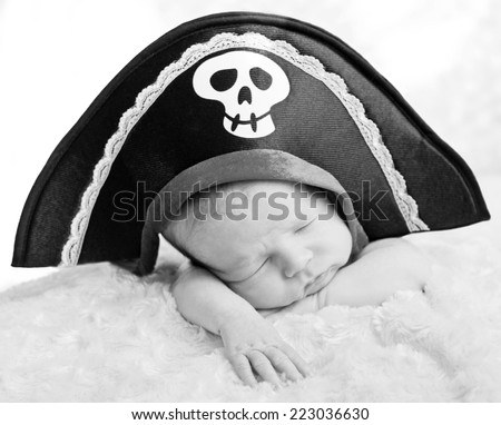 sleeping newborn baby in a pirate hat (soft focus) ( black and white )