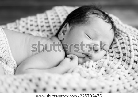 portrait cute newborn baby sleeping to knit a blanket ( black and white )
