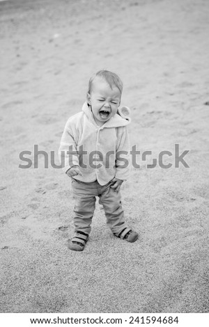 Funny Toddler baby cries outdoors in spring time ( black and white )