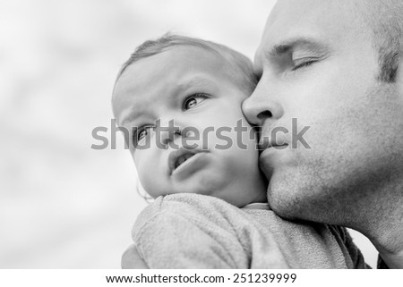 caring father calms toddler son outdoors  ( black and white )