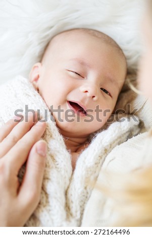 smiling newborn baby sleeps next to her mother