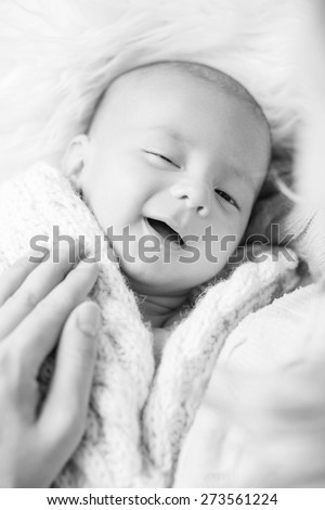 smiling newborn baby sleeps next to her mother ( black and white )