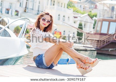 Beautiful young brunette woman sitting on the floor in summer clothes.. Summer time.