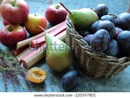 Seasonal fruits- apples, pears and plums in a wooden wicker