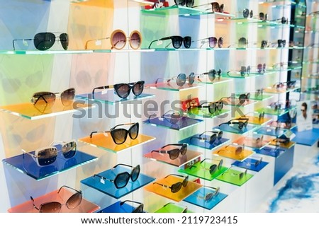 Different assortiment of UV protective eyewear frames on display panels in optical store. Select of functional sunglasses in local optic shop. Eyecare, vision concept Photo stock © 
