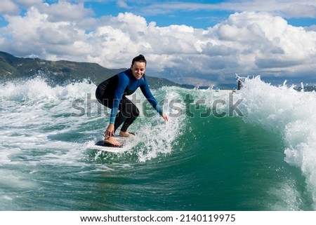 Similar – Image, Stock Photo Female athlete in wetsuit on calm lake shore