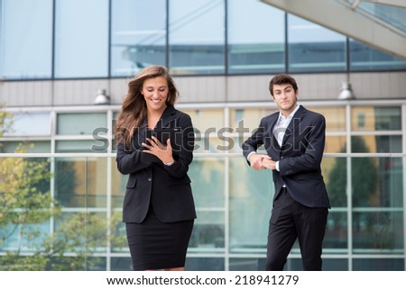 A young business couple standing in a modern buildings environment with a laptop computer